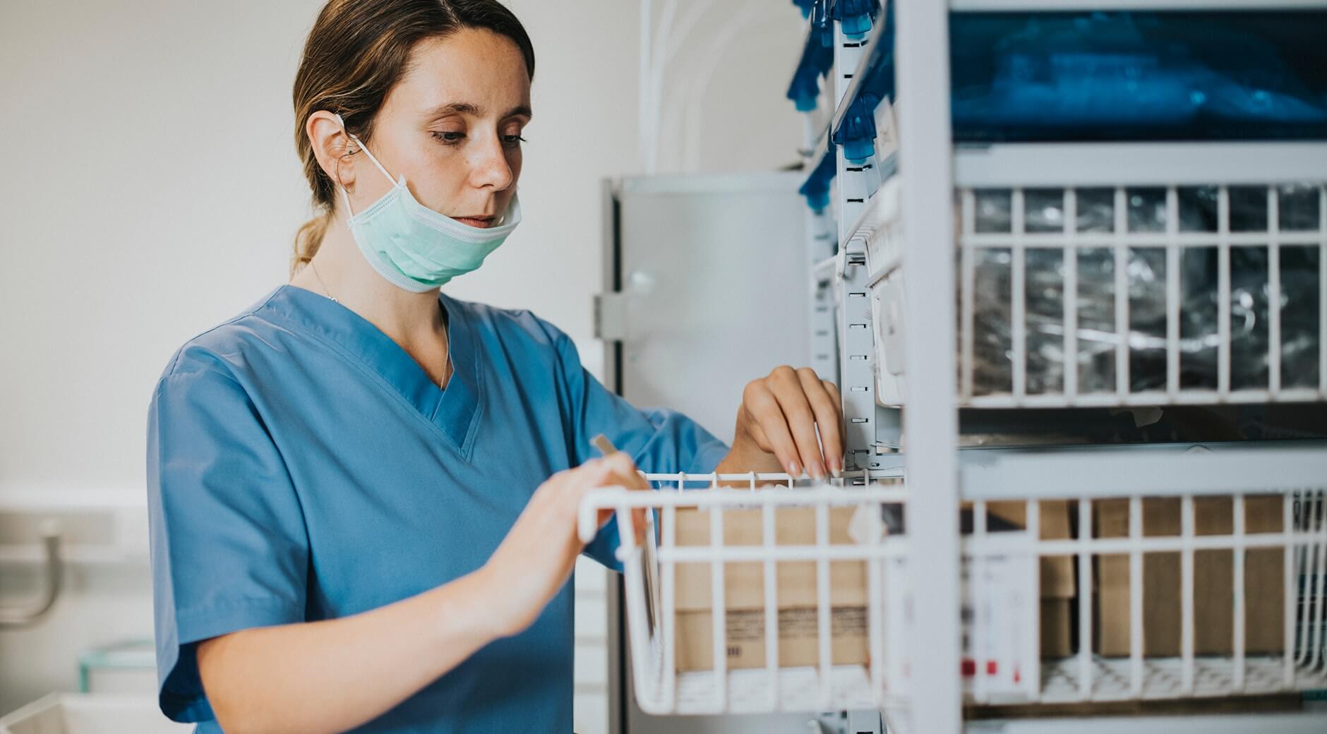 nurse pulling medical supplies from a wire basket