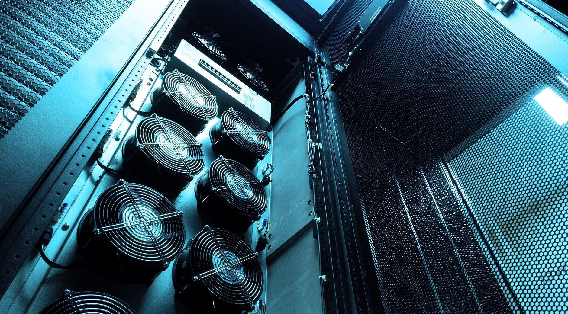 Close-up of industrial cooling fans with steel fan guards inside a data center server rack